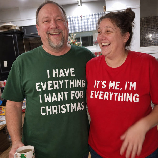 A couple laughing in their kitchen wearing the matching tees