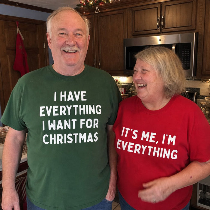 A couple laughing in their kitchen wearing the matching green and red tees